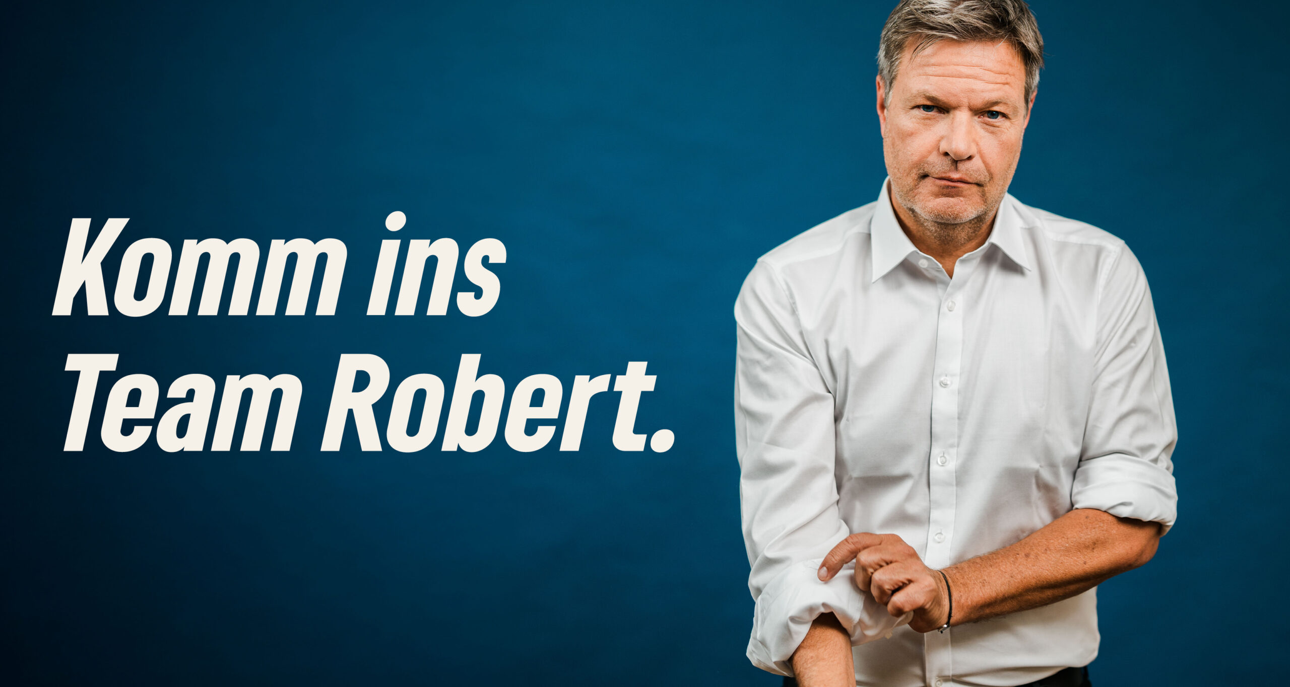 Neben dem Schriftzug "Komm ins Team Robert" steht Robert Habeck und krempelt den rechten Hemdsärmel hoch.